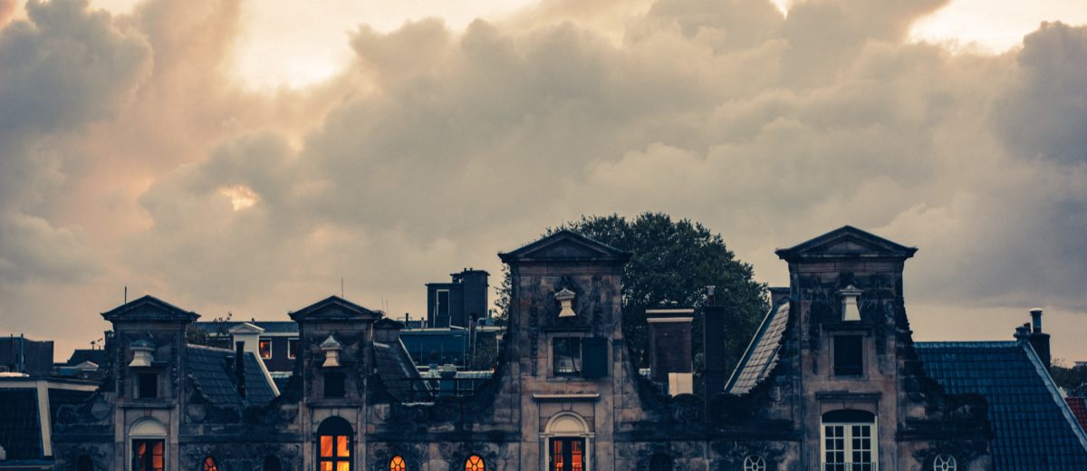 photo of clouds over old building rooftops